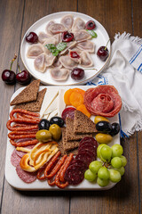 Traditional meal with dumplings and assorted cured meats on rustic table