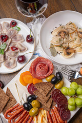 Traditional meal with dumplings and assorted cured meats on rustic table