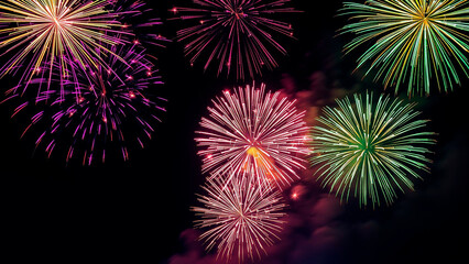 Colorful fireworks exploding in the night sky with vibrant bursts of light and smoke trails display