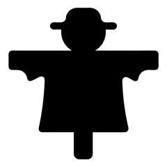 Black silhouette of a scarecrow with a hat standing in a field
