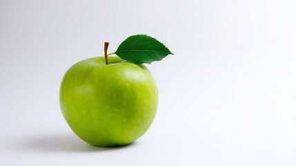 Fresh, crisp green apple with a leaf and stem on a bright white background. Healthy food.