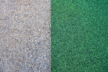 Top-down view of a contrasting surface between exposed aggregate concrete and green rubber softfall...