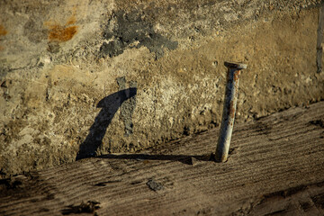 Rusty nail embedded in wood as a symbol of decay and memory