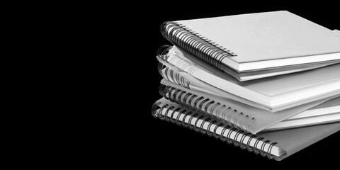 Collection of  stack of several spiral bound notebooks against a plain black background real image, no blur, clear image, hd, full hd, photos, isolated white background