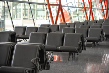Empty airport terminal waiting area with chairs.