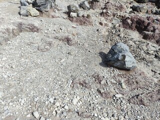 A harsh yet striking volcanic ecosystem, displaying varied ground texture and clear signs of hot steam emissions from the earth.