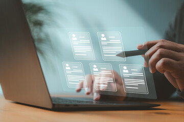 Recruiter browsing digital resumes on futuristic interface using a stylus and laptop. Concept of...