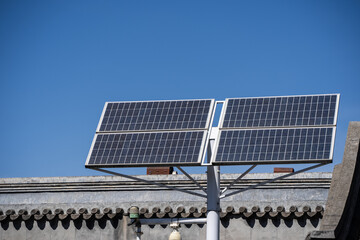 Pole mounted with solar panels, clear blue sky background.