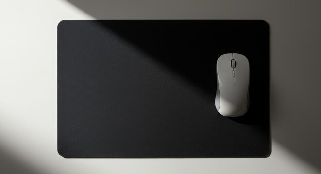 A minimalist and modern mousepad and mouse with a slanted light with an unusual yet beautiful camera angle,