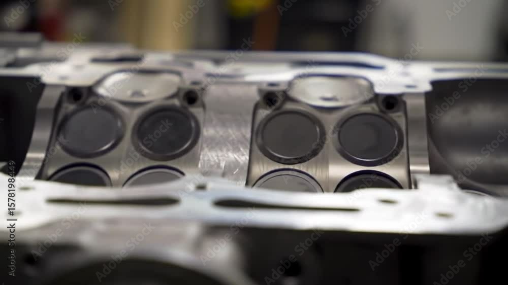 Poster close up of a disassembled silver engine block showing the intricate internal components under brigh