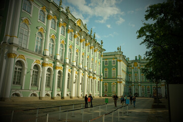 Inside St. Petersburg's Winter Palace, opulent halls boast dazzling chandeliers, gilded columns,...