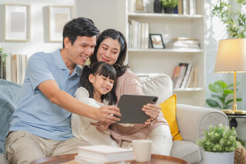 Portrait of happy multi-generation Asian family with dad mom and kids using smartphone digital...