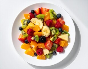 Colorful mixed fruit on a white plate, bright daylight, top-down composition