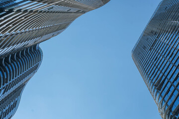 Low angle view of skyscraper with glass window and clear blue sky background for business and...