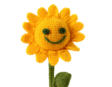 A whimsical crocheted sunflower with a happy face stands against a stark black backdrop, radiating warmth and playful charm, transparent background