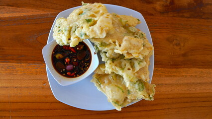 A high-angle, close-up view of a plate of crispy Indonesian Tempe, a fried Indonesian dish.