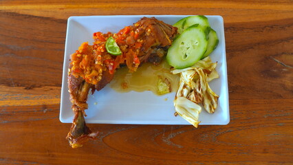 Delicious Indonesian Fried Chicken with Spicy Sauce, Cucumber, and Cabbage.