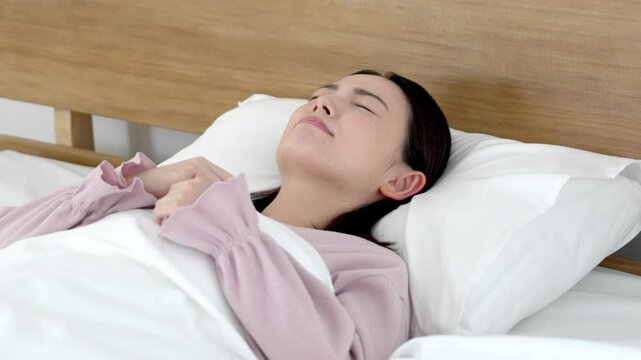 ベッドで寝付けない女性