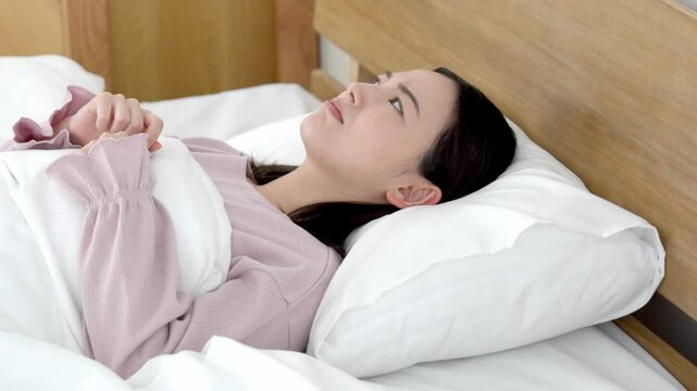 ベッドで寝付けない女性