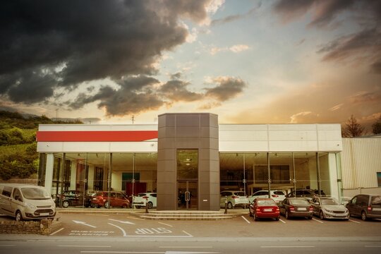 Fototapeta Cars by building against cloudy sky