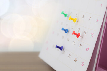 Desk calendar with pins for reminder in office workplace concept of time management agenda event planner or personal organization for business meeting and schedule planning or holiday plan.