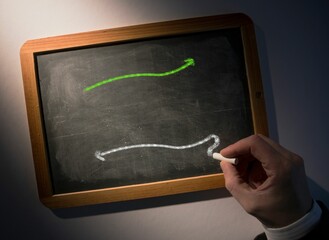Hand drawing arrows on chalkboard