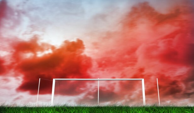 Fototapeta Football goal under red cloudy sky