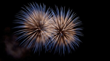 Stunning firework display of blue and gold light explodes in the dark sky for a holiday celebration