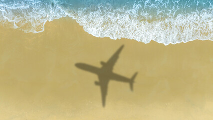 Aerial view of shadow passenger plane silhouette and sandy beach blue sea with waves at sea beach summer vacation sea travel concept