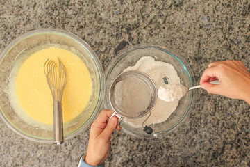Overhead View of Hands Sifting Flour with Hand Crank Sifter for Baking