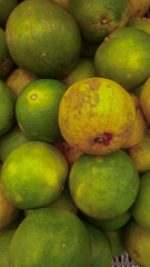 Close-up of a Pile of Fresh Green and Yellow Oranges at a Local Market for Sale