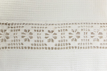 Embroidery banner with holes on a vintage white patterned table cloth
