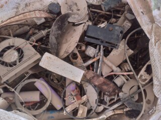 A pile of discarded electronic waste (e-waste), including old circuit boards, cables, and various defunct gadgets. 