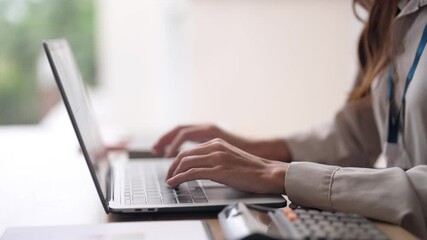 Confident Asian businesswoman hands typing laptop keyboard work analyze data create business report productive office environment - Powered by Adobe