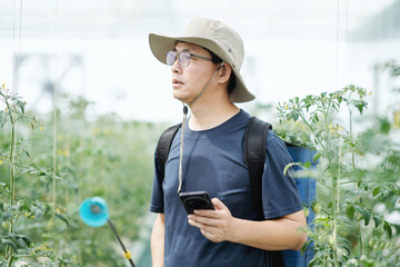 asian male farmer working in greenhouse
