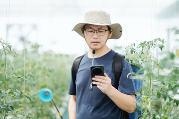 asian male farmer working in greenhouse