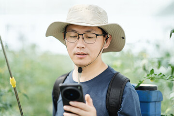 asian male farmer working in greenhouse