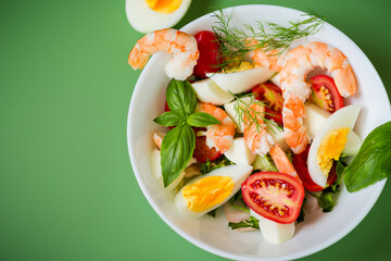 Vegetable salad with seafood and cheese for lunch on a green background