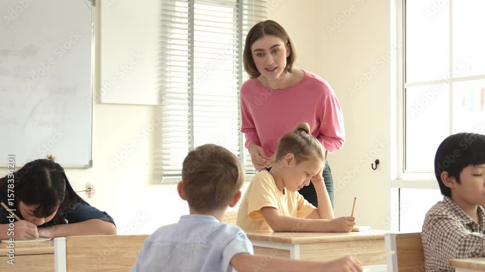 Poster energetic smart teacher explain classwork to caucasian boy at classroom while multicultural student 