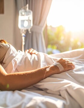 Persona descansando en cama de hospital con v&iacute;a intravenosa conectada, luz natural entrando por la ventana, escena tranquila de recuperaci&oacute;n, atenci&oacute;n m&eacute;dica y cuidado personal en entorno cl&iacute;nico