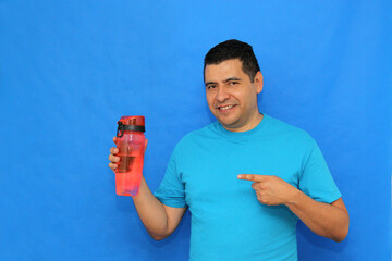 40-year-old dark-skinned Latino man shows his plastic bottle to carry water and avoid waste