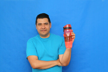 40-year-old dark-skinned Latino man shows his plastic bottle to carry water and avoid waste