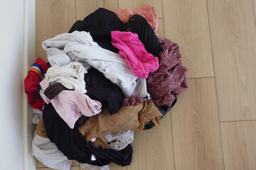 Laundry pile mixed with clean and dirty clothes on floor