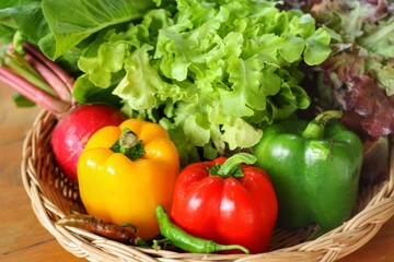 Close up at Fresh organic vegetables including radish,sweet pepper and green Lettuce in weave basket on table.Fresh harvested pesticide and GMO free vegetables good for health and environment.