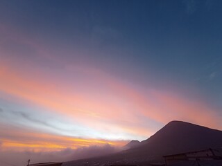 A breathtaking sunset sky with soft gradient colors embraces the silhouette of majestic mountains — a serene and elegant moment captured perfectly.
