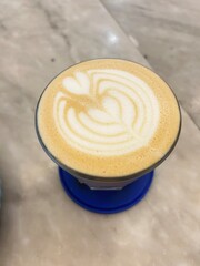 photo of latte art of coffee with blue coaster.