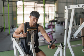 Strength Training. Man exercising on gym machine with focus and determination.