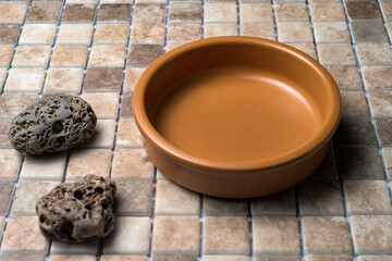 Handcrafted ceramic bowl placed on decorative white stones, styled with a minimalist touch