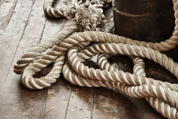 A sailor ropes is laying spread out on a wooden floor
