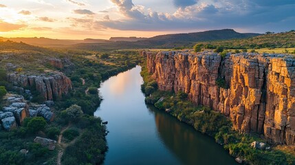 Winding river cutting through majestic cliffs, offering a breathtaking view of natureÃ¢Â?Â?s beauty.